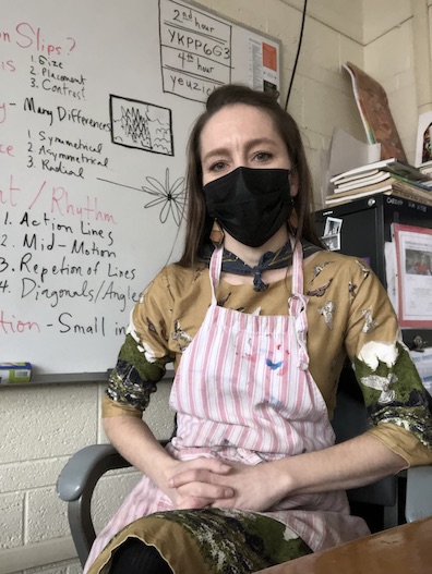 Roberta sitting at her desk in the UHS art room.